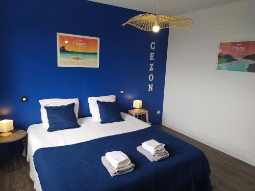 - une chambre bleue avec un lit et des serviettes dans l'établissement L'ilot des abers Maison de vacances, à Lannilis