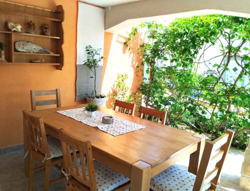 einen Esstisch mit Stühlen und einem Tisch in der Unterkunft Franc Apartments Island Vir Croatia in Vir