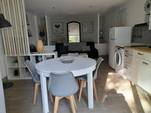 uma cozinha e sala de estar com uma mesa branca e cadeiras em Gîte La Passiflore Barjols em Barjols