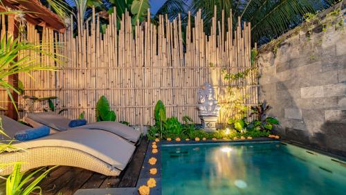a backyard with a swimming pool and a fence at Ganesh Villa in Ubud