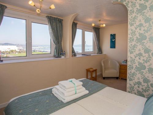 ein Schlafzimmer mit einem Bett mit Handtüchern darauf in der Unterkunft The Briars in Paignton