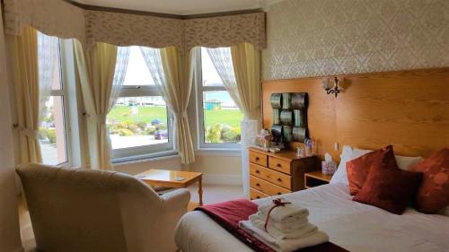 a bedroom with a bed and a chair and a window at The Briars - Adults Only in Paignton