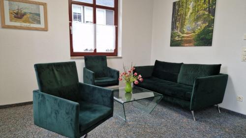 ein Wohnzimmer mit 2 Stühlen, einem Sofa und einem Tisch in der Unterkunft Markt 9 Appartements Oberwiesenthal in Kurort Oberwiesenthal
