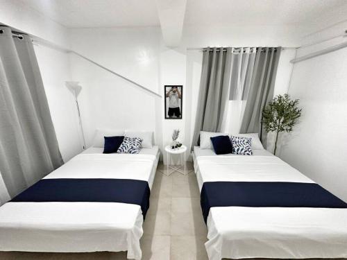 15 Secs to Beach-2BR w/ Kitchen & Newly Renovated في بوراكاي: سريرين في غرفة ذات لون أبيض وأزرق