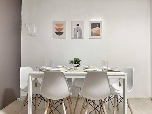 15 Secs to Beach-2BR w/ Kitchen & Newly Renovated في بوراكاي: غرفة طعام بيضاء مع طاولة بيضاء وكراسي بيضاء
