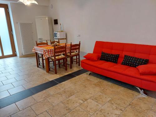 a living room with a red couch and a table at Iori's House in Mergozzo