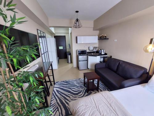 a living room with a couch and a kitchen at Cozy Studio Unit, Avida Towers Aspira in Cagayan de Oro