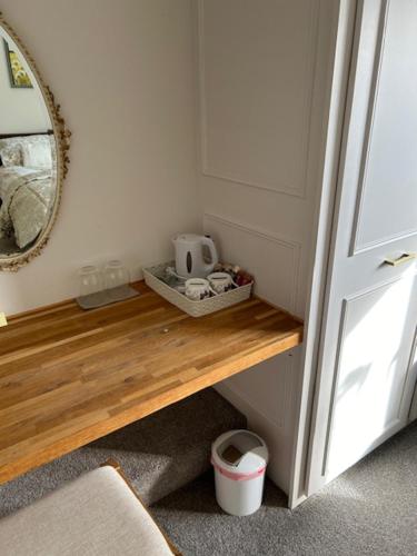 una camera con tavolo in legno, specchio e porta di Rock Park Farm B&B a Crediton