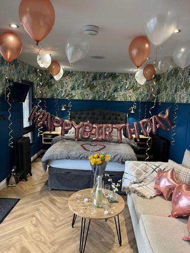 a bedroom with balloons and a bed with a couch at The Langland bay look out in Swansea