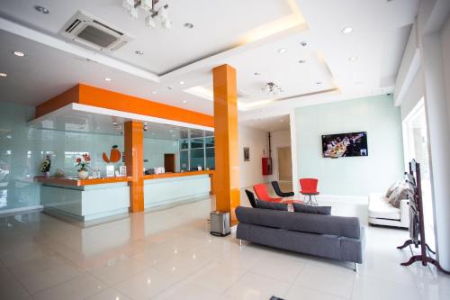 a living room with a couch and a table at The Original Orange Hotel in Nakhon Si Thammarat
