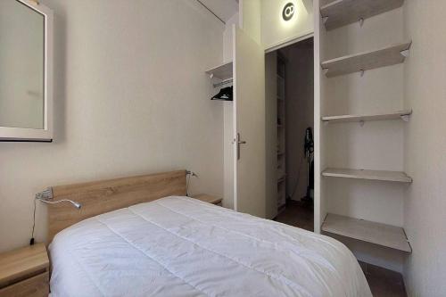 - une chambre avec un lit dans une pièce dotée d'étagères dans l'établissement HACIENDA BEACH I Jolie villa T4 avec clim piscine Rochelongue Cap d'Agde, au Cap d'Agde