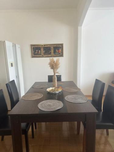 a dining room table with black chairs and a wooden table with a vase at Семейная с детьми Центр in Oral