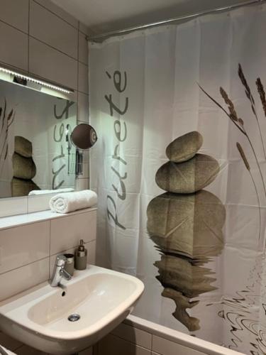 a bathroom with a sink and a shower curtain at Cocoon 77 Apartments in Stuttgart