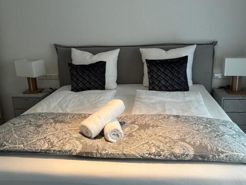 Una cama con dos toallas enrolladas encima. en Cocoon 77 Apartments, en Stuttgart