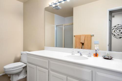 a white bathroom with a sink and a toilet at Palm Desert Oasis - With Beatiful Golf Courses in Palm Desert