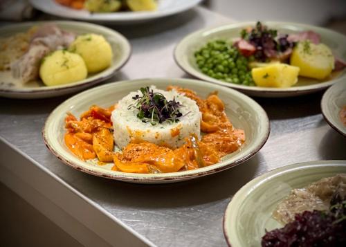 a plate of food on a table with plates of food at Traditionsgasthaus Goldener Löwe Riesa Restaurant & Pension in Riesa