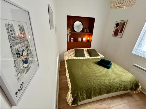 une petite chambre avec un lit et un miroir dans l'établissement la parenthèse champenoise, à Reims