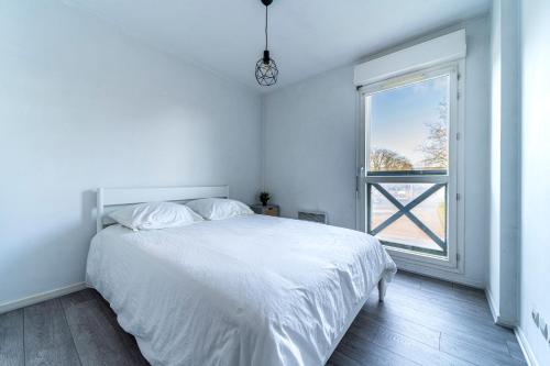 a white bedroom with a bed and a window at T2 avec Terrasse Citadelle in Lille