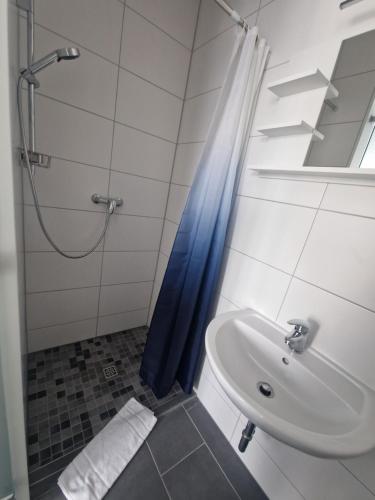 a bathroom with a blue shower curtain and a sink at BusinessQuartier Berlin in Berlin