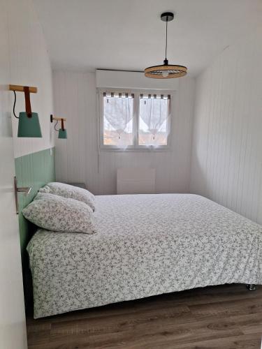 a bedroom with a bed and a window at La Pinède du Chéou, Piscine, Logement indépendant, Parking, Draps, Wifi fibre in Mimizan