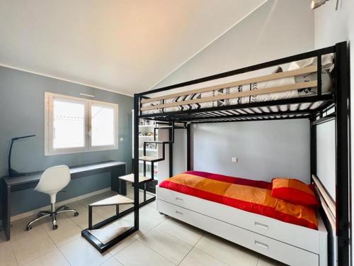 a bedroom with a bunk bed with a desk and a chair at Maison Climatisée avec Piscine in Toulouse