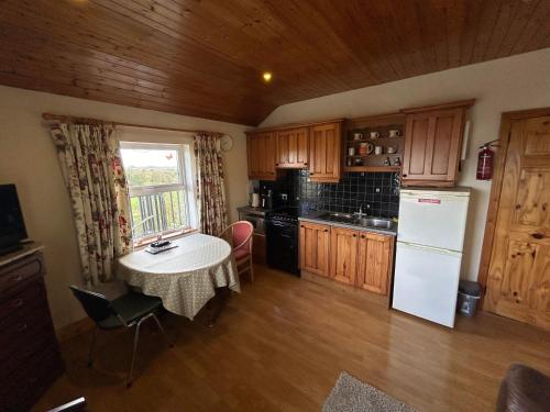 eine Küche mit einem Tisch und einem weißen Kühlschrank in der Unterkunft Tara Vista Apartment in Navan