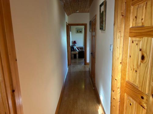 um corredor que leva a uma sala de estar com painéis de madeira em Tara Vista Apartment em Navan