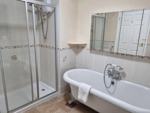 y baño con bañera, ducha y lavamanos. en Spacious Detached Home with Beautiful Seaviews, sleeps 6, en Trimingham