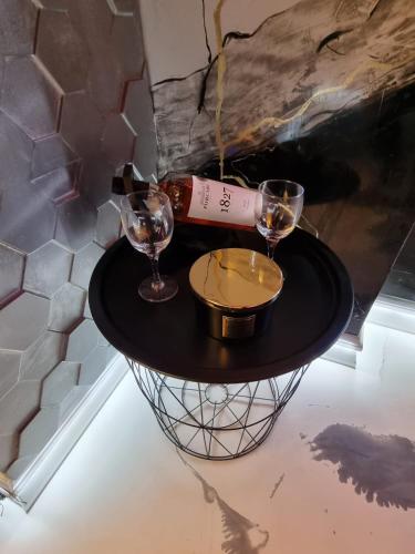 a table with a bottle of wine and two glasses at The Marble Room in Petroşani