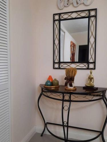 a console table with a mirror on a wall at 5 Min from Dunn River Fall 2 Bedroom Townhome Pool Balcony in Mammee Bay