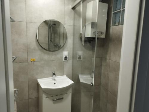 a bathroom with a sink and a mirror at Apartament Parkowy in Bielsko-Biała