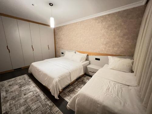 2 łóżka w sypialni z białą pościelą w obiekcie Apartament Koha 