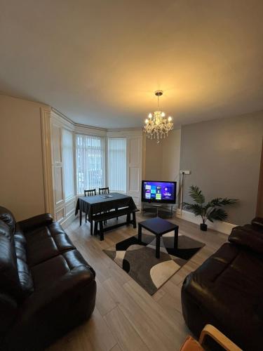a living room with a couch and a flat screen tv at Newcastle, Powburn, fully equipped kitchen 4 bedrooms, 3 king & 2 single beds in Newcastle upon Tyne