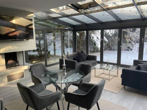 sala de estar con mesa de cristal y sillas en Moderne Ferienwohnung in Waldrandlage mit einem Hauch von Luxus en Burgthann