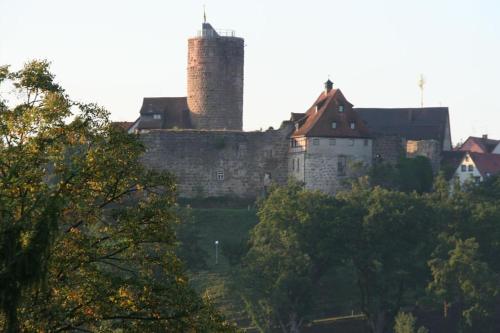a castle on top of a hill with trees at Moderne Ferienwohnung in Waldrandlage mit einem Hauch von Luxus in Burgthann