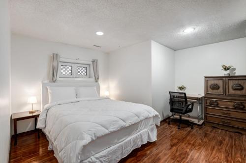 a bedroom with a bed and a dresser and a window at Cozy 2BR Walkout Suite Near YYC Free Parking in Calgary