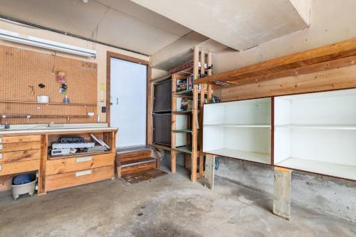 an empty room with wooden cabinets and shelves at Cozy 2BR Walkout Suite Near YYC Free Parking in Calgary