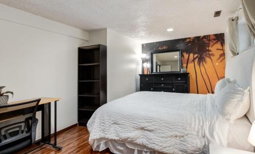 a bedroom with a bed and a dresser with a mirror at Cozy 2BR Walkout Suite Near YYC Free Parking in Calgary
