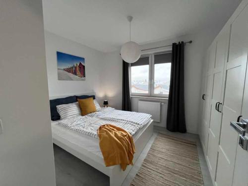 a white bedroom with a bed with a window at Pucka Marina in Puck