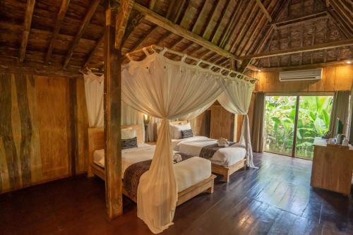 烏布的住宿－Ubud Art Resort，一间卧室配有两张床和一张天蓬床。