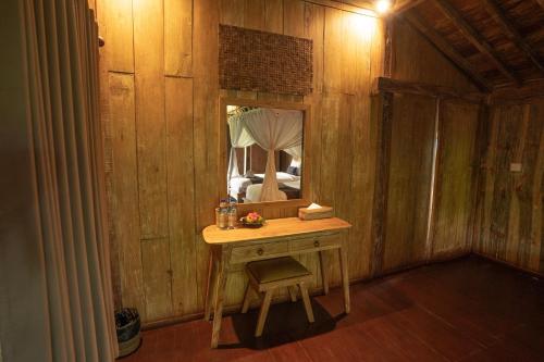 a wooden room with a table and a mirror at Ubud Art Resort in Ubud