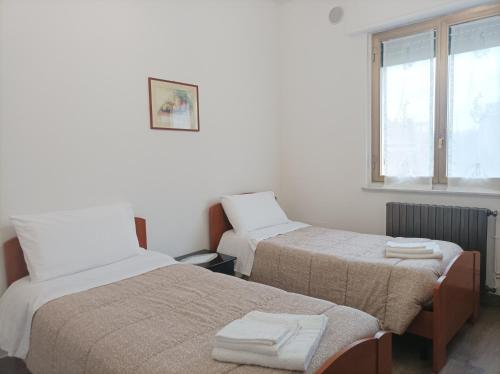 Habitación con 2 camas y ventana en Affitta camere Via Piave, en Foligno