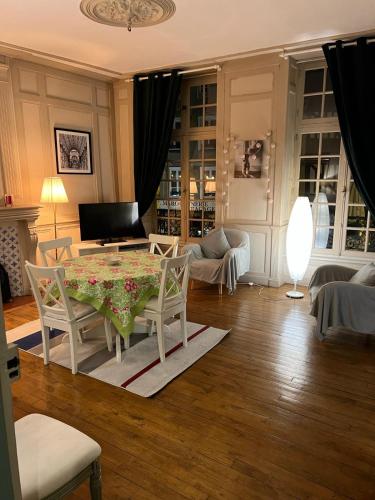 un salon avec une table et des chaises dans l'établissement EGLANTINE APPARTEMENT CENTRE HISTORIQUE DE DINAN, à Dinan