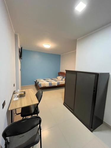 een kamer met een tafel en stoelen en een kamer met bedden bij Condominio Confortable in Talara