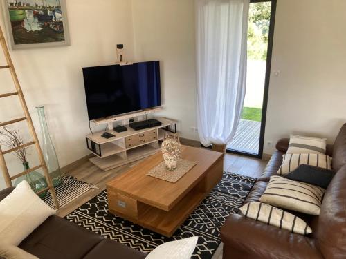 a living room with a couch and a tv at TROUZ AR MOR à 100m de la plage, jardin clos in Loctudy