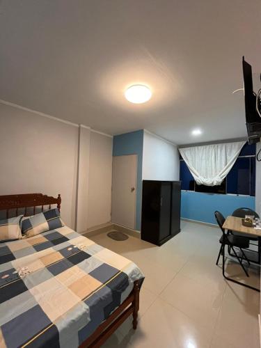 Un dormitorio con una cama y una mesa. en Condominio Confortable en Talara