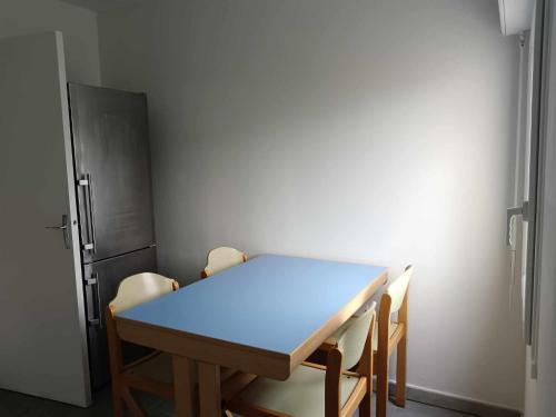 einen Tisch und Stühle in einem Zimmer mit Kühlschrank in der Unterkunft MAISON 4 CHAMBRES AVEC JARDIN in Dampierre-en-Burly
