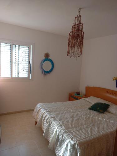 1 dormitorio con cama, ventana y espejo en Casas viejas en Arona