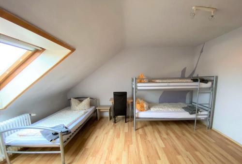 a attic room with two bunk beds and a window at Penthouse - 4-Zimmer und Terrasse in Karlsbad