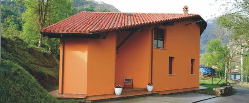 een klein oranje huis met een rood dak bij El Crucial in Cangas de Onís